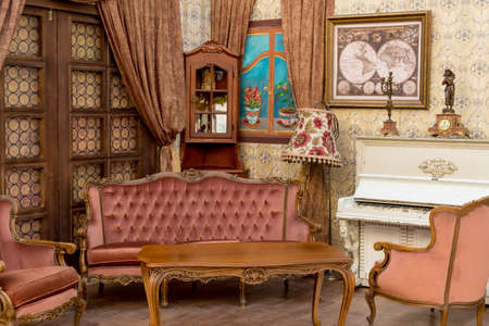 Vintage retro room setting with sofa, accessories, old rusty white piano. Ideal for postcard. Old chamber living room, french style, Victorian details and furniture. Antique decorations and colorsのeditorial素材