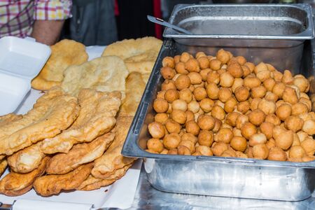 Homemade traditional hungarian dish named "langosi" during food festival, freshly baked or deep fried stack of doughnuts, on a plate, on a rustic napkin table setting. Fast food snack, sweet or saltyの写真素材
