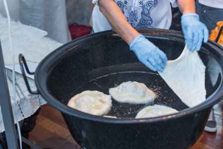 Homemade traditional hungarian dish named "langosi" during food festival, freshly baked or deep fried stack of doughnuts, on a plate, on a rustic napkin table setting. Fast food snack, sweet or saltyの写真素材