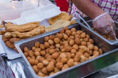 Homemade traditional hungarian dish named "langosi" during food festival, freshly baked or deep fried stack of doughnuts, on a plate, on a rustic napkin table setting. Fast food snack, sweet or saltyの写真素材