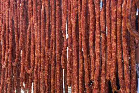 Assorted meat products, sausages, chorizo, spices on a dark table. View from above. Large selection of different dried spicy seasoned beef and pork sausages. Street food, fast food assortment of meatの写真素材