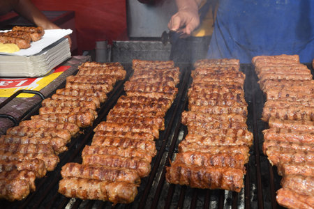 Chef grilling meat during cookout picnic or food event. Meat mix variety:sausages, pork, chicken, lamb, sheep, sardines, fried or grilled, unhealthy protein concept. oily food, cancerigen foodの写真素材