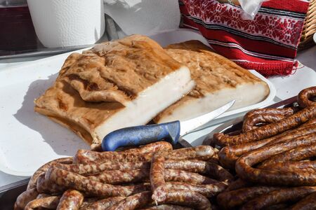 Assorted meat products, sausages, chorizo, spices on a dark table. View from above. Large selection of different dried spicy seasoned beef and pork sausages. Street food, fast food assortment of meatの写真素材