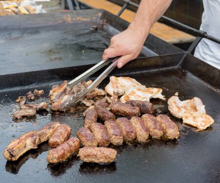 Fresh grilled meat sausage pork chicken minced meat "mici" during hotel brunch buffet outside outdoor in the garden by the pool. Fresh Food Buffet Brunch Catering Dining Eating Party Sharing Conceptの写真素材