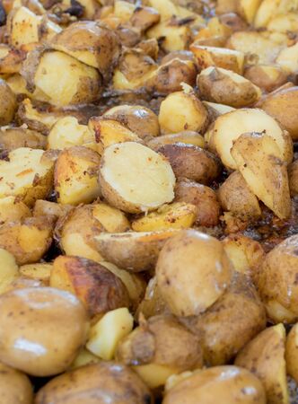Potato wedges in skin roasting frying in large pan during hotel brunch buffet outside outdoor in the garden by the pool. Fresh Food Buffet Brunch Catering Dining Eating Party Sharing Concept.の写真素材