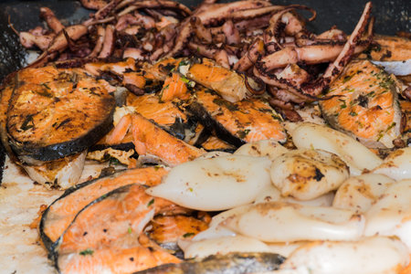 Fresh grilled seafood mix octopus, fish, squid, shrimp during hotel brunch buffet outside outdoor in...