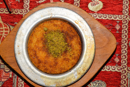 Turkish dessert kunefe with pistachio powder. Kunafa, kadayif with pistachio powder and cheese hot...