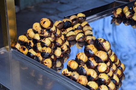 Roasting chestnuts on a street stall in Istanbul, Turkey. Selective focus. Street food snack traditional in winter autumn season.の写真素材
