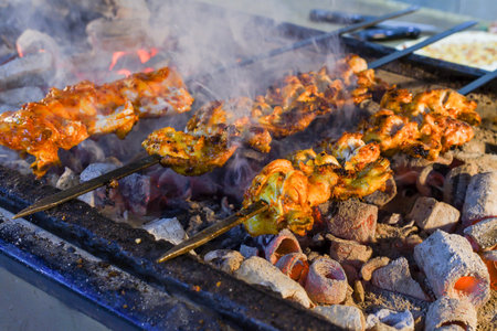 Roasted meat cooked at barbecue. Grilled kebab cooking on metal skewer. BBQ fresh beef meat chop slices. Traditional eastern dish, shish kebab. Grill on charcoal and flame, street food, Istanbulの写真素材