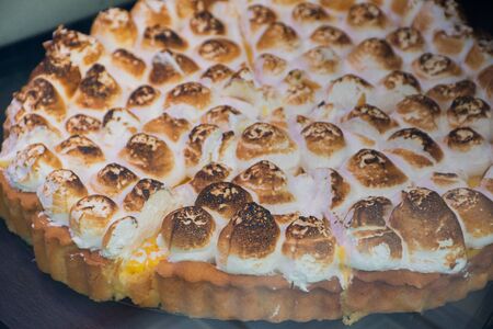 Lemon tart meringue, whole sliced piece on the tableの写真素材