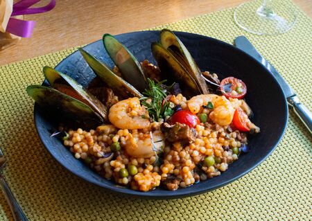 Bulgur, coucous pasta, green peas, lentil, cherry tomato, mussels and mushroom italian specialtyの写真素材