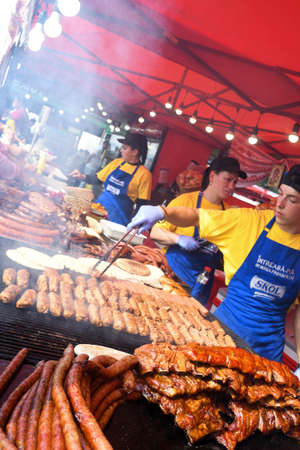 Chef grilling meat during cookout picnic or food event. Meat mix variety:sausages, pork, chicken, lamb, sheep, sardines, fried or grilled, unhealthy protein concept. oily food, cancerigen foodのeditorial素材