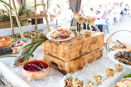 Luxury catering by the pool, food bloggers event, banquet, wedding, festive, hotel brunch buffet arrangement with clean simple design, decorations, boat filled with ice. Modern design and decorationsの写真素材