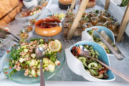 Luxury catering by the pool, food bloggers event, banquet, wedding, festive, hotel brunch buffet arrangement with clean simple design, decorations, boat filled with ice. Modern design and decorationsの写真素材