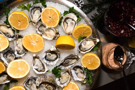 Fresh oysters with lemon on ice during hotel brunch buffet outside outdoor in the garden by the pool. Fresh Food Buffet Brunch Catering Dining Eating Party Sharing Conceptの写真素材