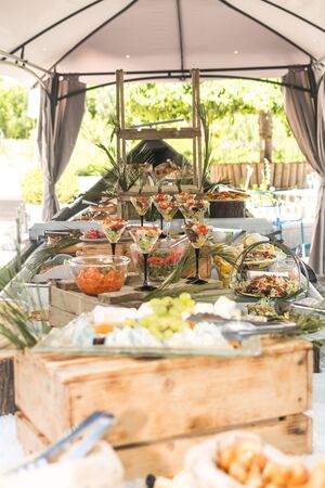 Luxury catering by the pool, food bloggers event, banquet, wedding, festive, hotel brunch buffet arrangement with clean simple design, decorations, boat filled with ice. Modern design and decorationsの写真素材