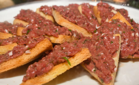 Beef tartar with various sauces dressings during hotel brunch buffet outside outdoor in the garden by the pool. Fresh Food Buffet Brunch Catering Dining Eating Party Sharing Conceptの写真素材