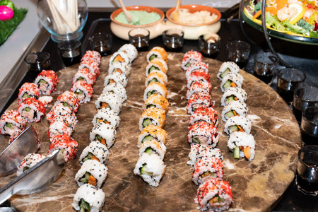 Colorful assortment of sushi rolls on a marble plate during brunch buffet or catering eventの写真素材
