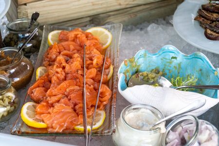 Luxury catering by the pool, food bloggers event, banquet, wedding, festive, hotel brunch buffet arrangement with clean simple design, decorations, boat filled with ice. Modern design and decorationsの写真素材