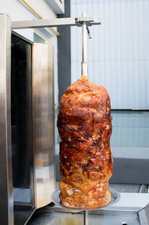 Grilled skewered chicken on spit, a traditional meat shaved, served inside kebab sandwich in Mediterranean and Arab countries in Middle East, cooked isolated on pure white background. Fast food dishの写真素材