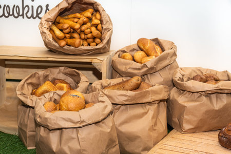 Selection of Fresh baked bread baskets and paper bags with bread roasted in the oven, croissants,...