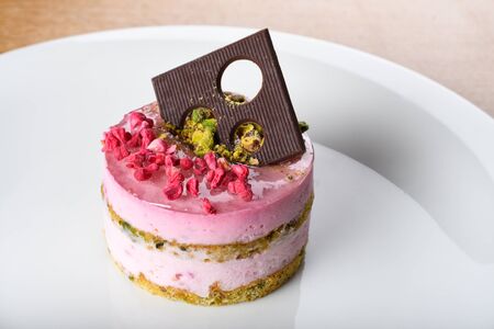 Ricotta cheese cake with pistachio and raspberry. Cheesecake is a sweet dessert consisting of one or more layers. The main, and thickest layer, consists of a mixture of soft, fresh cheese, eggs, and sの写真素材