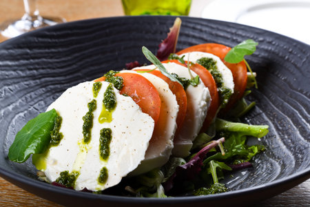 Caprese salad is a simple Italian salad, made of sliced fresh mozzarella, tomatoes, and sweet basil,...