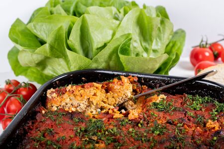 Traditional Romanian dish named "Varza a la Cluj" made from stewed cabbage, tomato paste and minced meat, rice and dill, red napkin, salad and tomatoes, bread and condimentsの写真素材