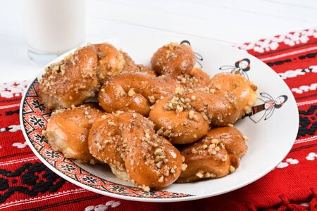 Concept of romanian cuisine. Homemade Mucenici, traditional desserts made in the figure 8 to look like garlands, smeared with honey and chopped nuts.の写真素材