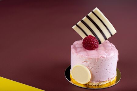 Raspberry vanilla and white chocolate mousse dessert with logo space isolated on yellow and brown. Minimalist conceptual design, flat lay with space for copy text, simple colorful paper backgroundの写真素材