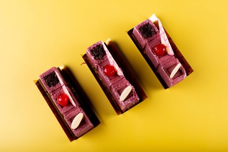 Cherry vanilla and white chocolate mousse dessert with logo space isolated on yellow and brown. Minimalist conceptual design, flat lay with space for copy text, simple colorful paper backgroundの写真素材