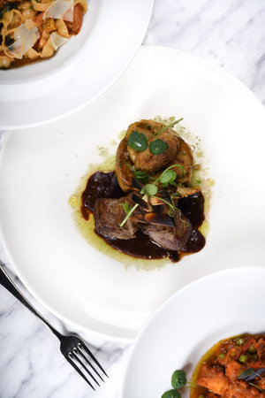 Lamb chops with baked baby potatoes and artichoke sauteed and red wine sauce . Traditional Italian...