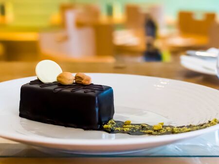 Selection of desserts: amandine, meringue with chocolate and strawberries, caramel cake, in a restaurant setting, blurred backgroundの写真素材