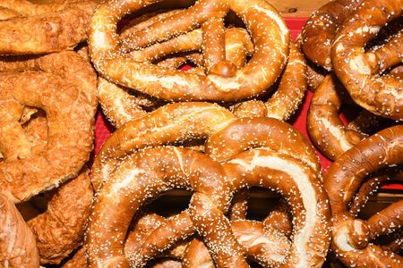 Bavarian authentic pretzels for Oktoberfest or Autumn Fest, Christmas or festive celebration. German or Austrian salted or with seeds brezel bread ideal for morning snack, cut in half with ham, cheeseの写真素材