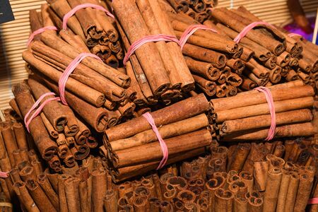 Bunch of cinnamon sticks for sale on counter top at the Christmas market. Healthy aromatic spice used in cooking and medicine, aromatherapyの写真素材