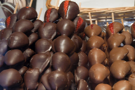Chocolate fondue with fresh berries. Fondue with melted chocolate and strawberry. Strawberry skewers with melted chocolate on sticks at fruit stall for sale at Vienna Christmas market festivalの写真素材
