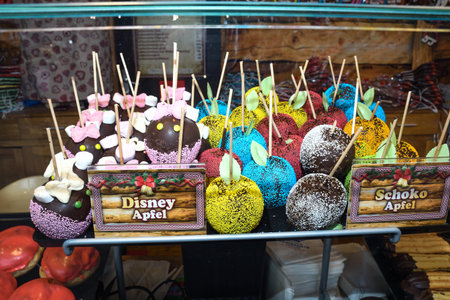Sweet glazed red toffee candy apples on sticks for sale on farmer market or country fair. Thanksgiving and Halloween homemade red caramel glazed toffee apples with sticksのeditorial素材