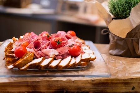 Varied meat cuts on a platter, Easter or Christmas food during hotel brunch buffet outside in the garden by the pool. Fresh Food Buffet Brunch Catering Dining Eating Party Sharing Conceptの写真素材
