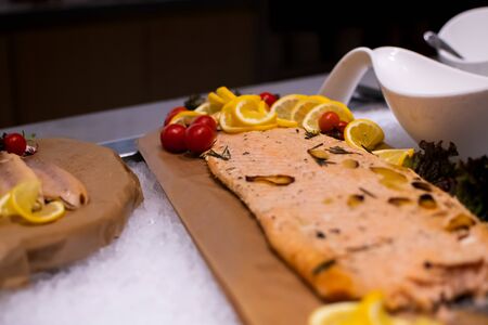 Fresh salmon fish fillet on a platter, Easter or Christmas food during hotel brunch buffet outside in the garden by the pool. Fresh Food Buffet Brunch Catering Dining Eating Party Sharing Conceptの写真素材