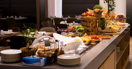Sunday Brunch Menu with salads, meat, cheese cuts and vegetables during hotel brunch buffet indoor restaurant setting.の写真素材