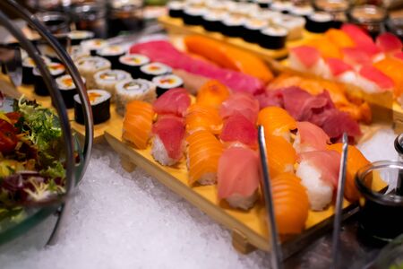 Sushi selection platter with maki, nigiri, rolls during hotel brunch buffet outside outdoor in the garden by the pool.の写真素材