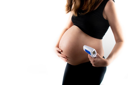 Temperature check with no contact termometer for pregnant woman. Coronavirus covid19 pandemic rules and regulations. Fever in pregnancy medicinal concept.の写真素材