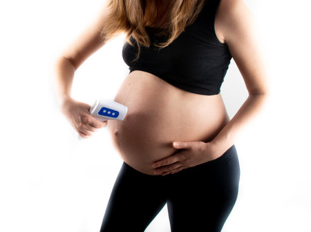 Temperature check with no contact termometer for pregnant woman. Coronavirus covid19 pandemic rules and regulations. Fever in pregnancy medicinal concept.の写真素材