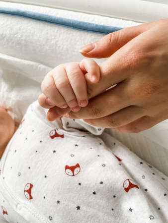 Baby boy holding motherâs hands. Love and affectionの写真素材
