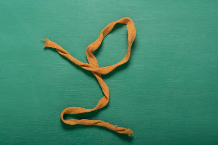piece of khaki yarn on a chalk green background, trapillo-type crochet thread. Abstract drawing, aerial photograph.の写真素材
