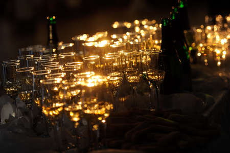 Champagne flautes prepared for a wedding reception with a ray of lightの写真素材