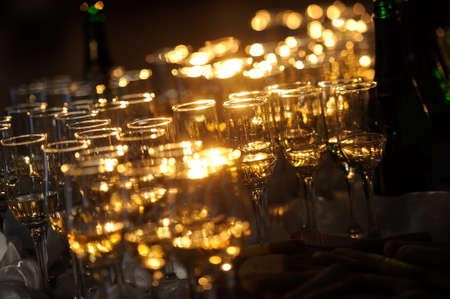 Champagne flautes prepared for a wedding reception with a ray of lightの写真素材