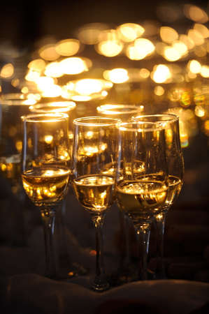 Champagne flautes prepared for a wedding reception with a ray of lightの写真素材
