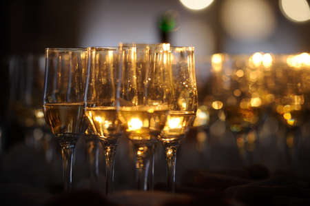 Champagne flautes prepared for a wedding reception with a ray of lightの写真素材