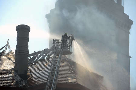 Firefighters douse a fire in an old buildingの写真素材